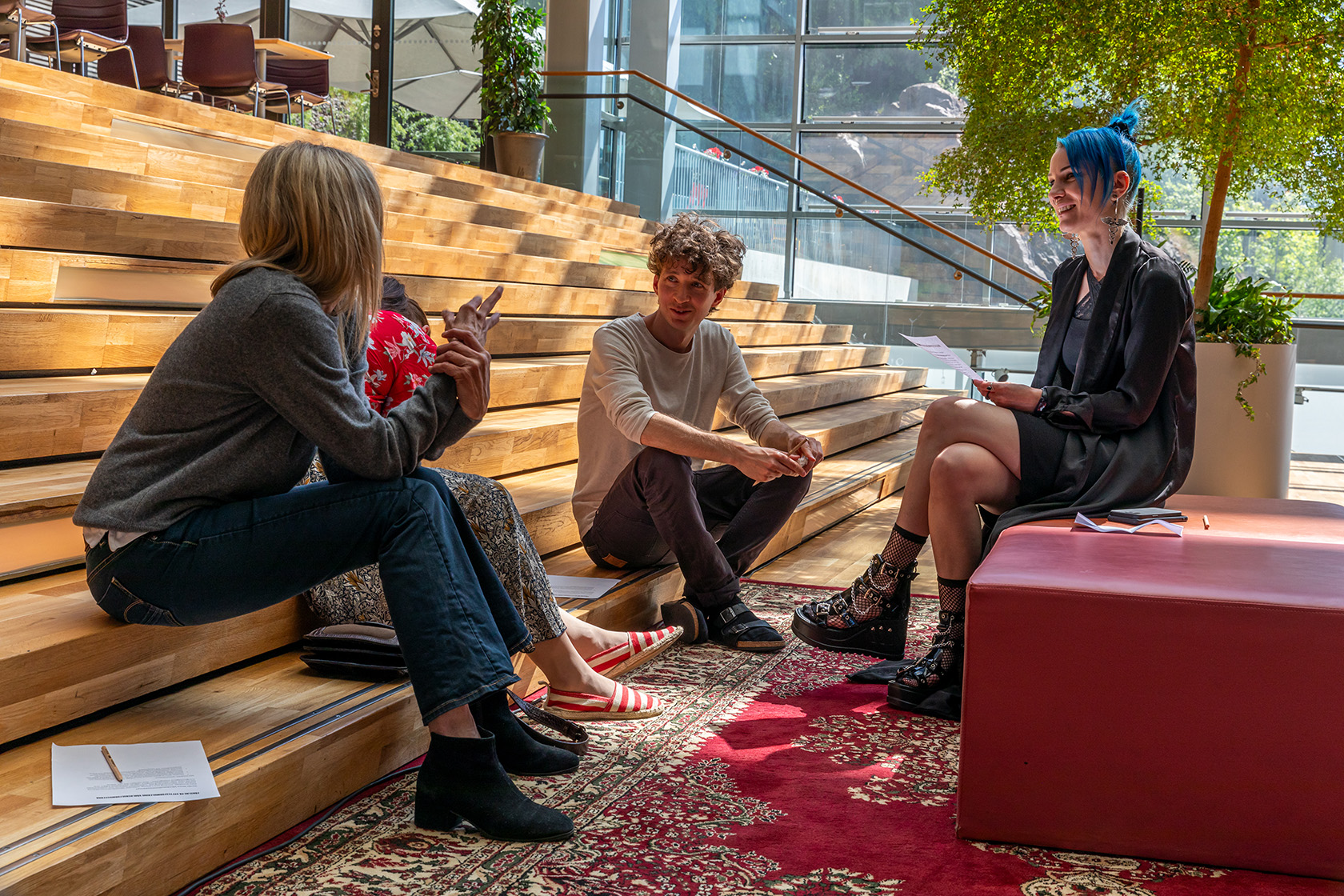 Personer som sitter i trappan och diskuterar